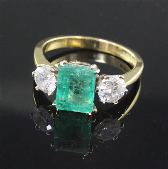 A modern 18ct gold, emerald and diamond three stone ring, size N/O